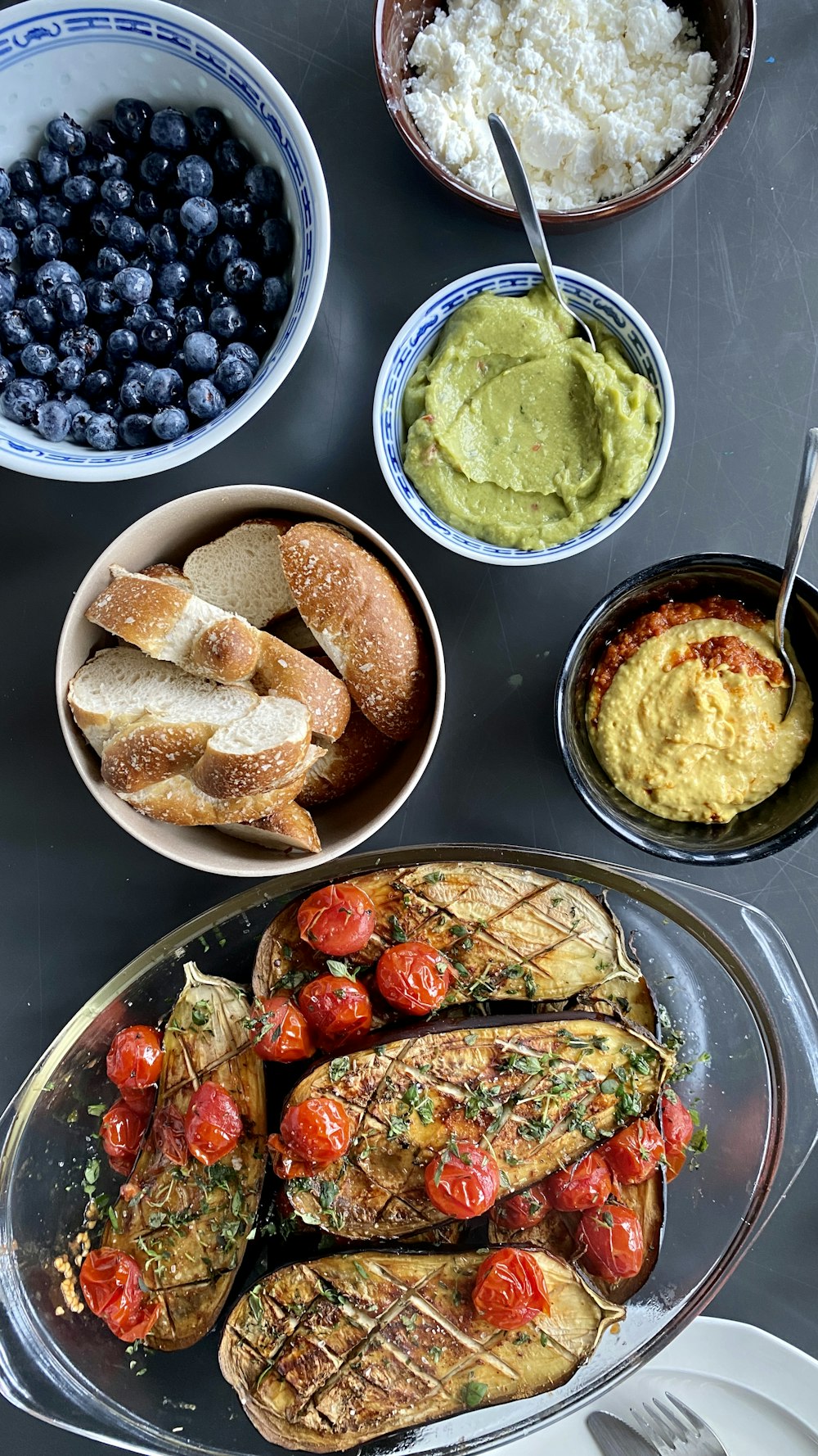 a table topped with plates of food and bowls of fruit