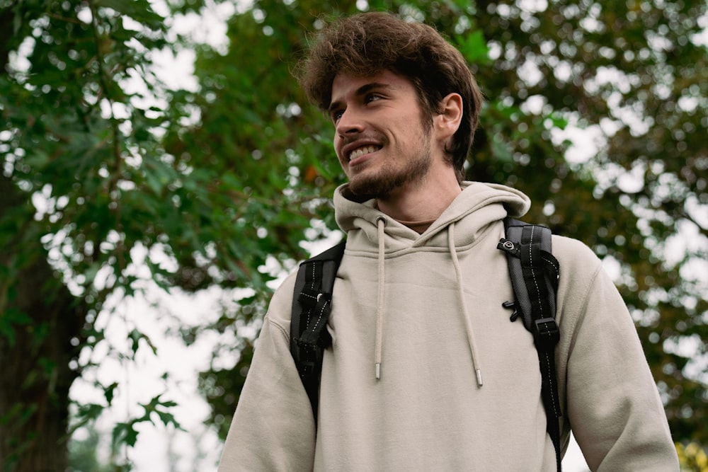 a man in a hoodie smiles at the camera