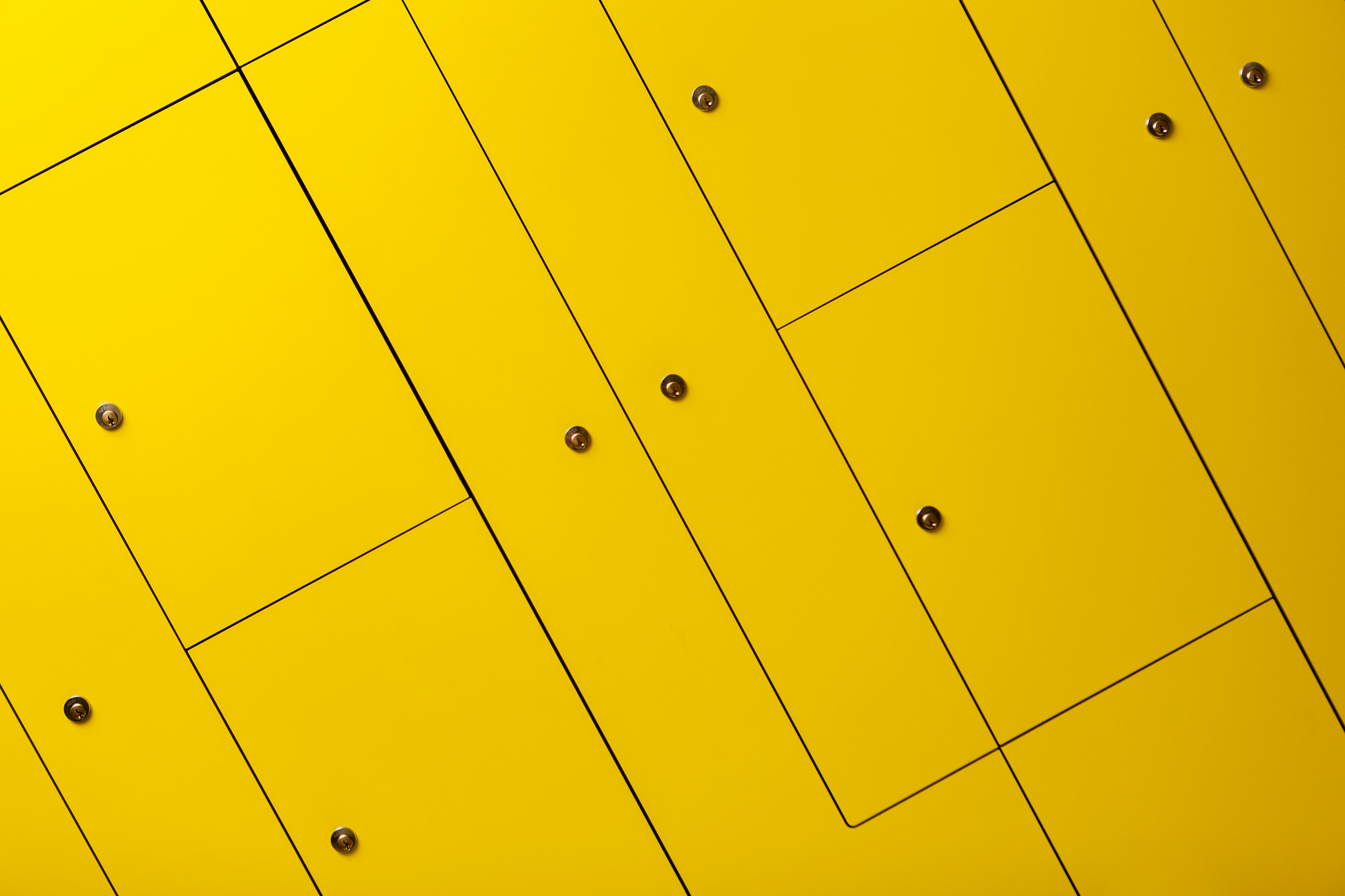 a close up of a yellow wall with rivets