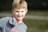 a young boy in a gray and orange shirt