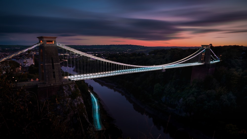 a suspension bridge over a river at night