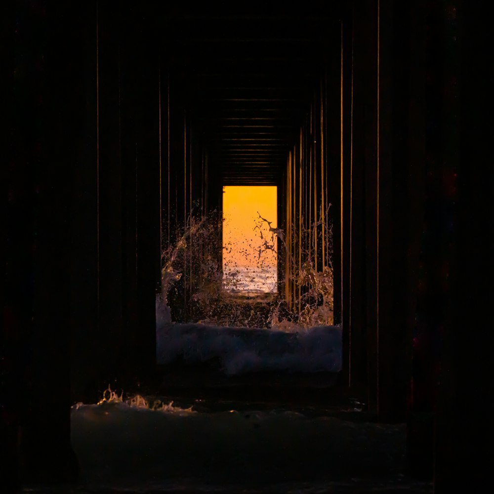 a view of the ocean through a dark tunnel