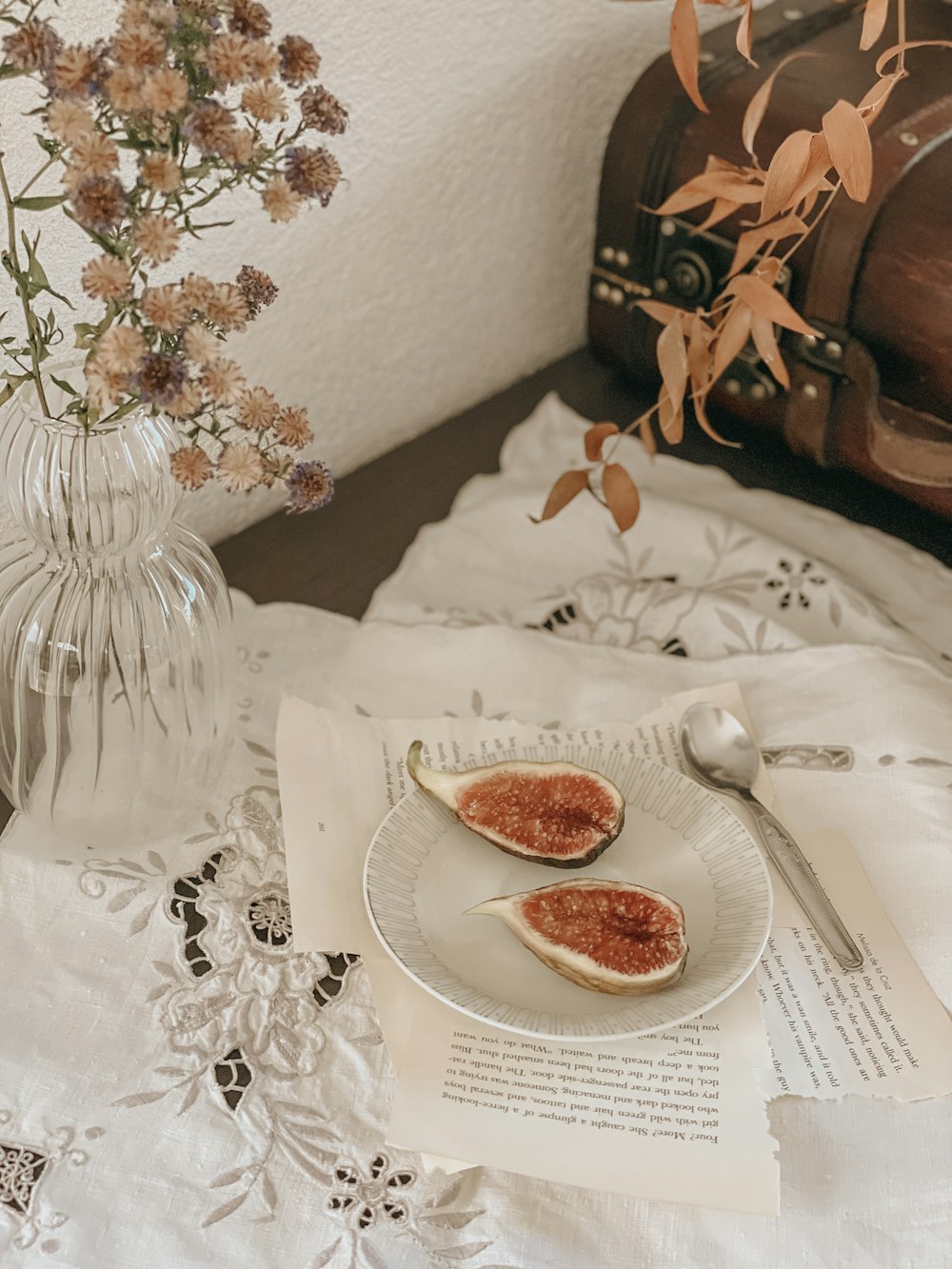 a plate of food sitting on top of a table next to a vase of flowers