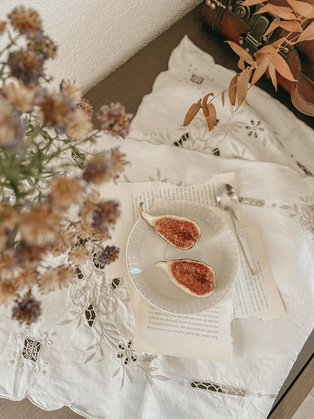 a plate of food sitting on a table next to a vase of flowers