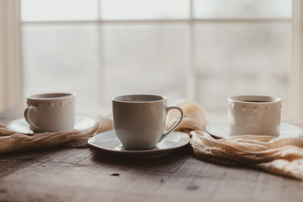 two coffee cups sitting on top of a wooden table