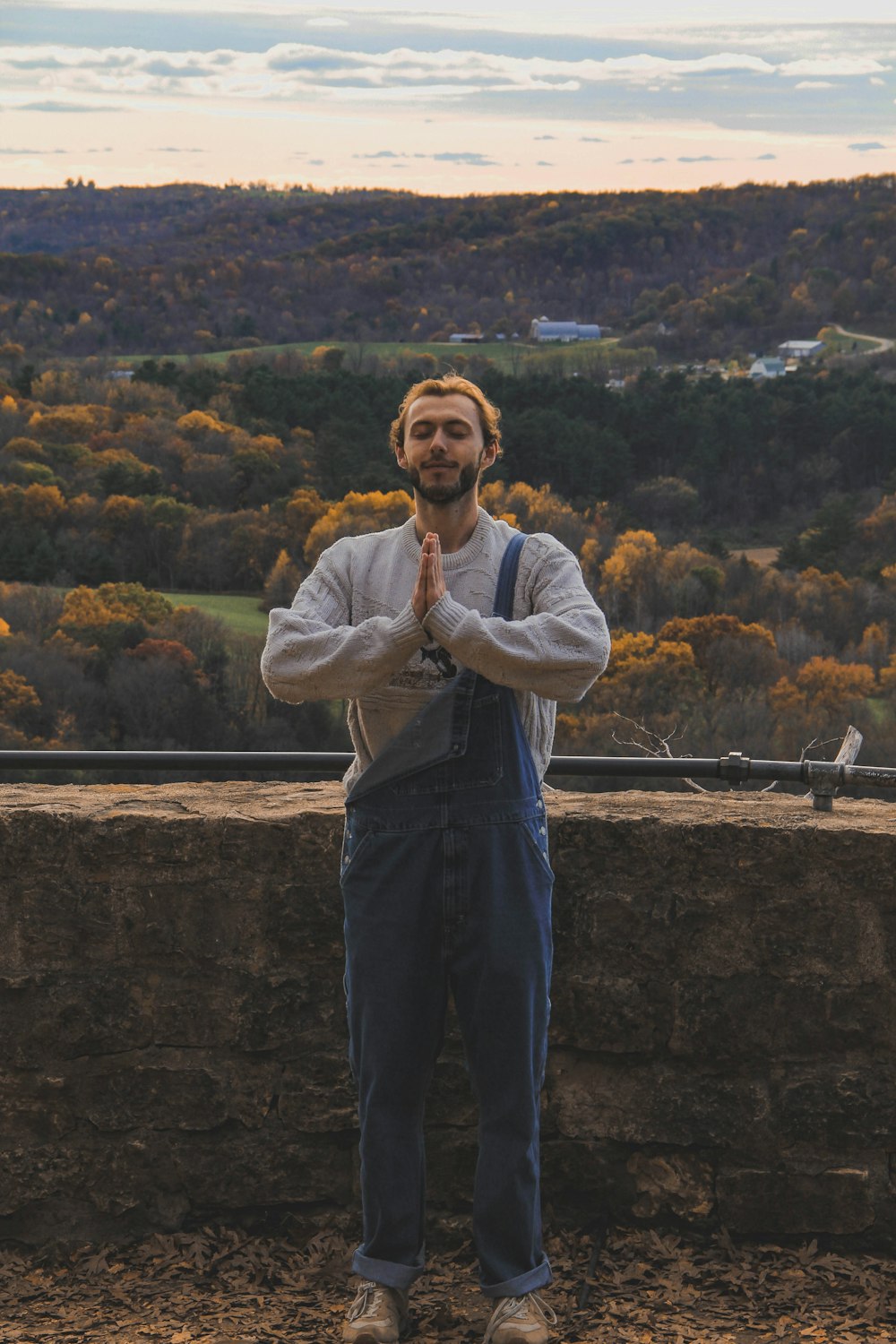 um homem de pé na frente de uma parede de pedra