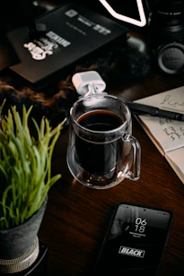 a cup of coffee sitting on top of a wooden table