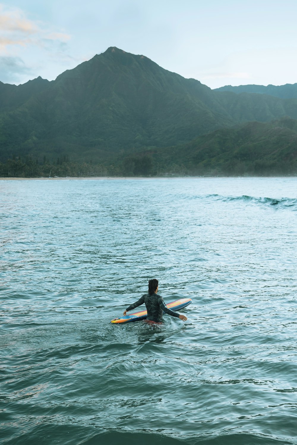 Una persona en un cuerpo de agua con una tabla de surf