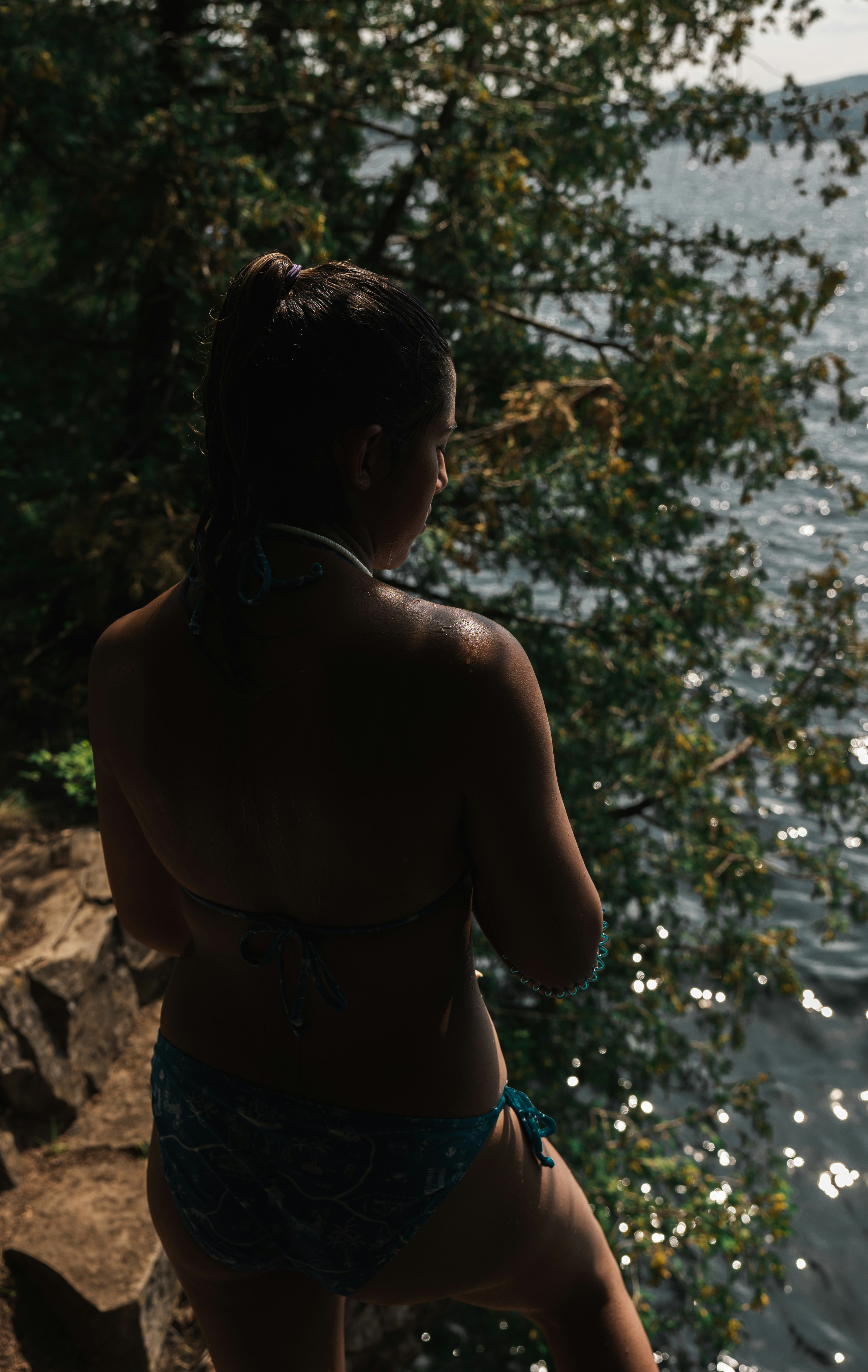 a woman in a bikini standing by the water