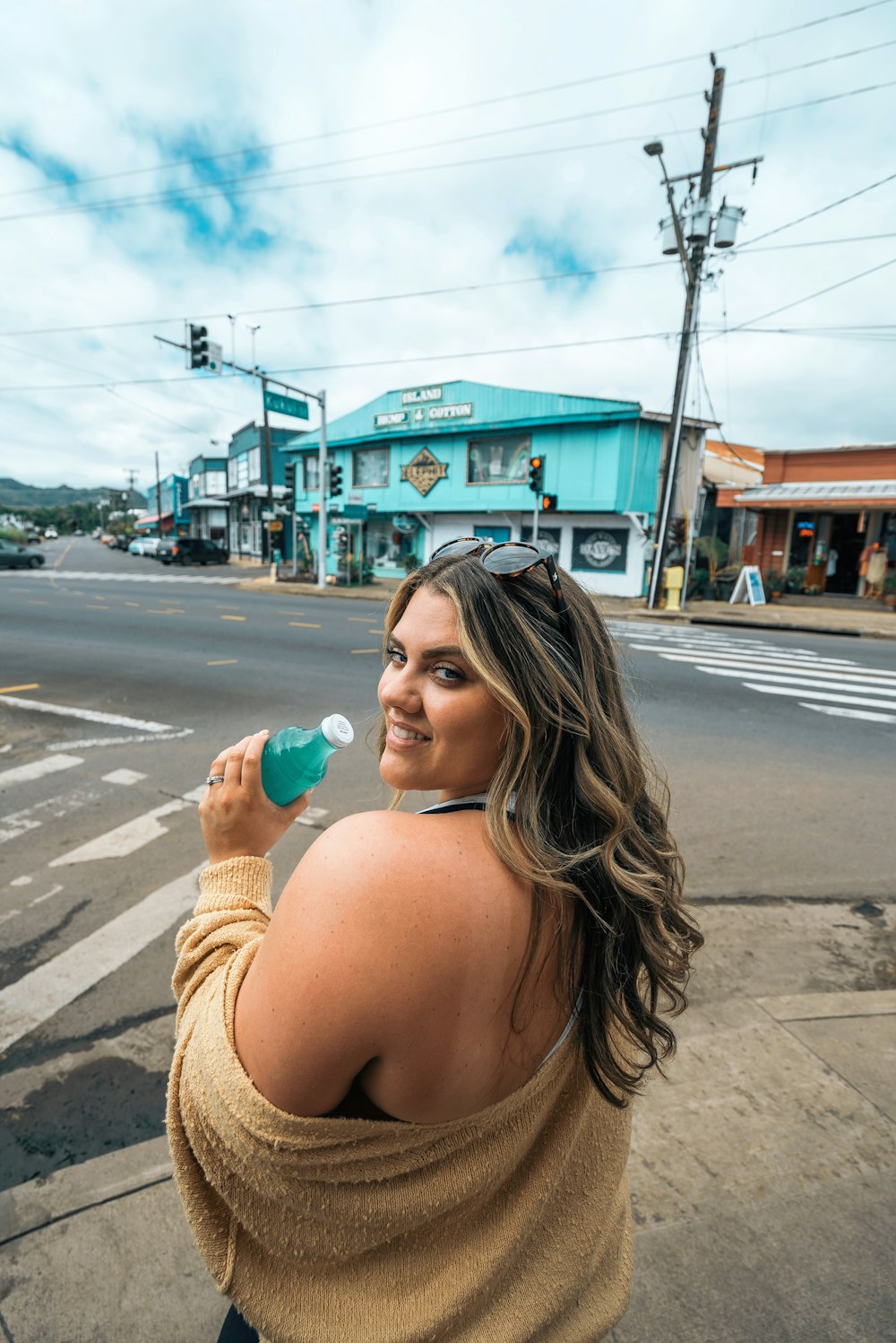 a woman standing on the side of a road holding a cup