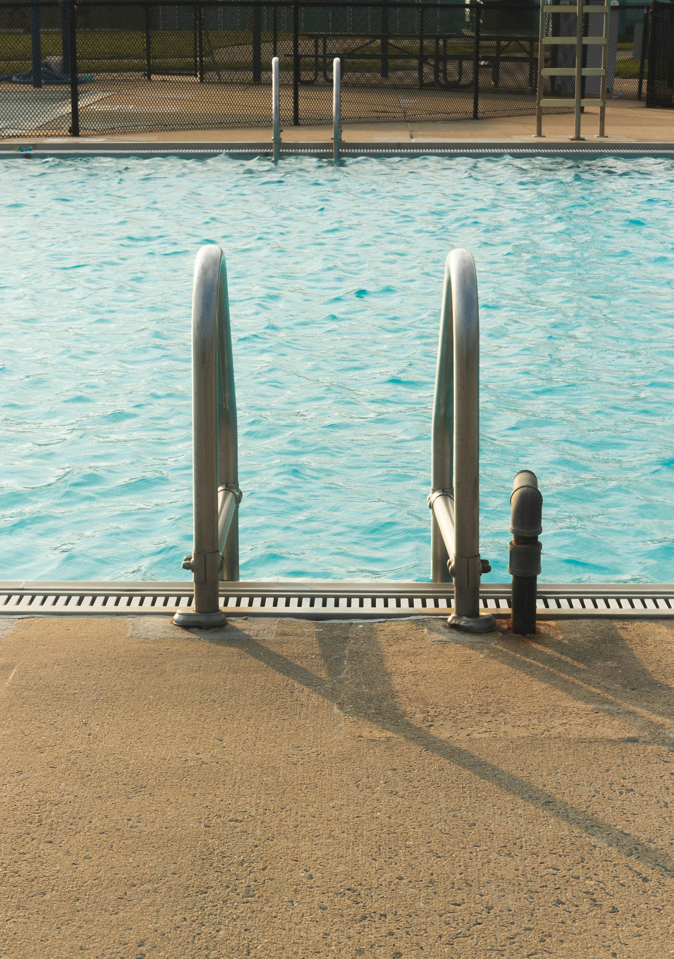a swimming pool with a metal railing next to it
