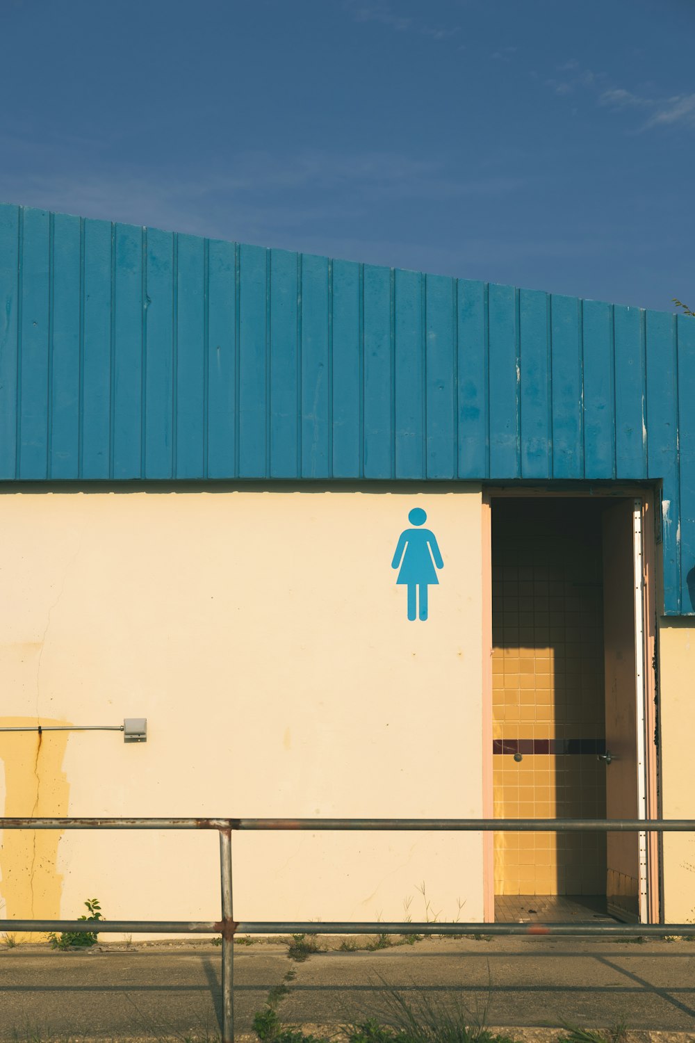 a blue and yellow building with a blue roof