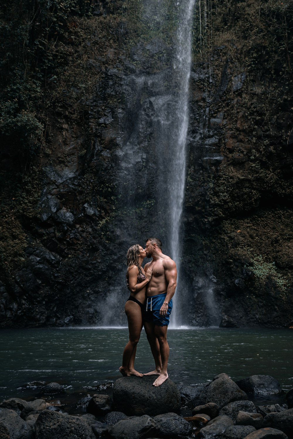 Un homme et une femme debout devant une cascade