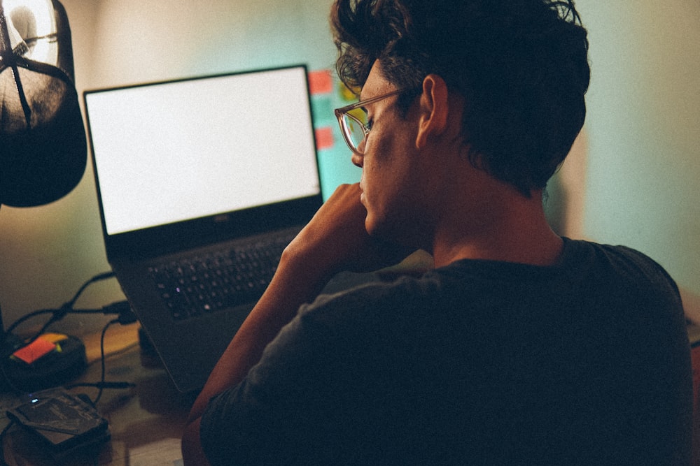 um homem sentado na frente de um computador portátil