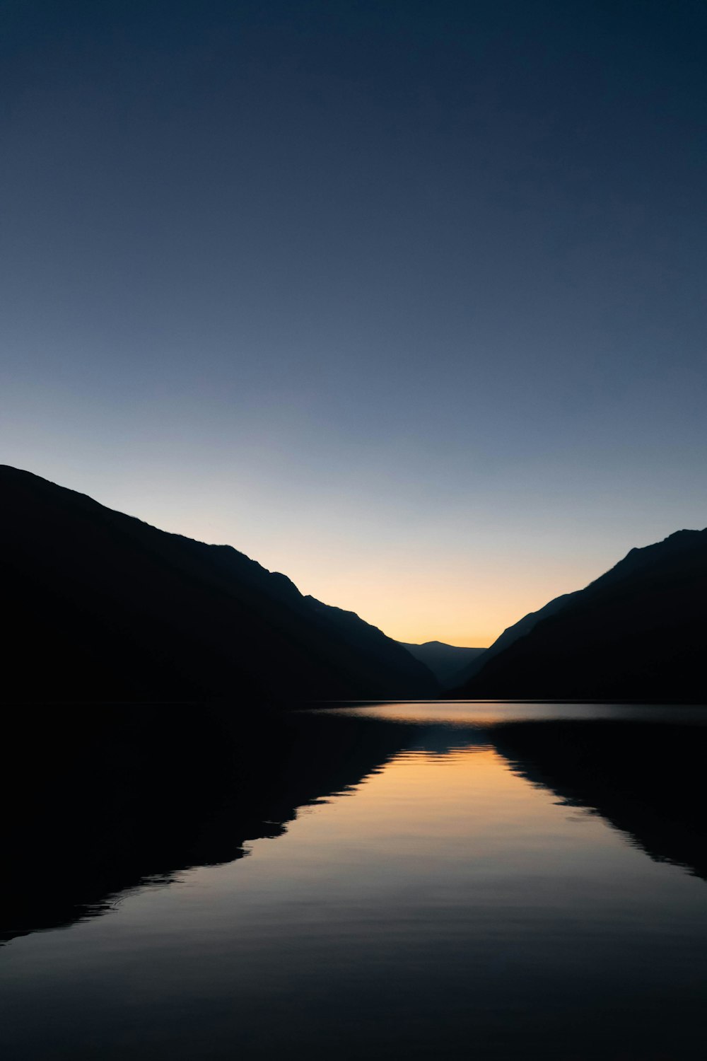 a body of water with mountains in the background