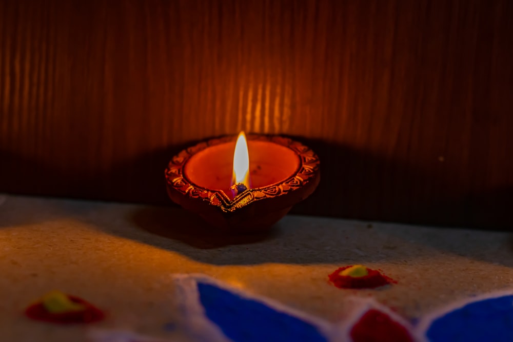 a lit candle sitting on top of a table