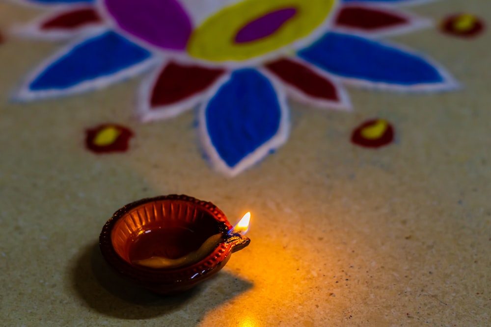 a small lit candle sitting on top of a table