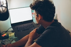 a man sitting in front of a laptop computer