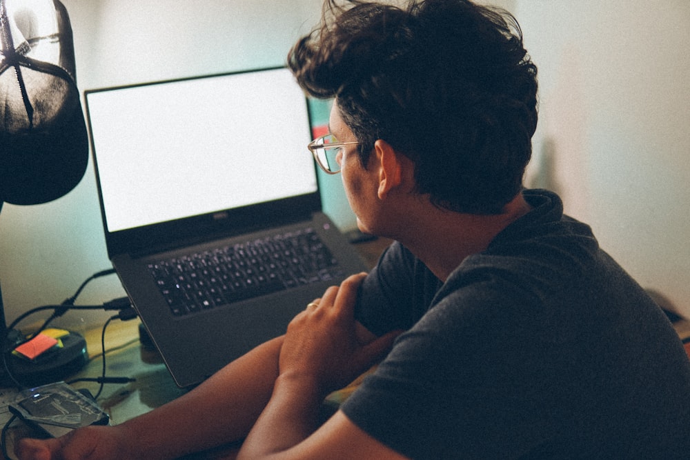 a man sitting in front of a laptop computer