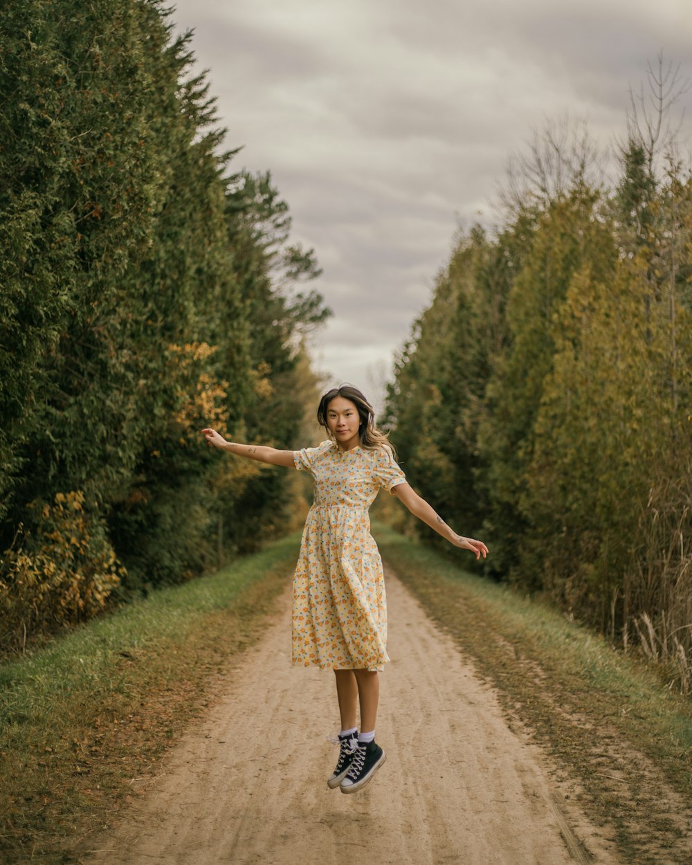 a woman in a yellow dress jumping in the air