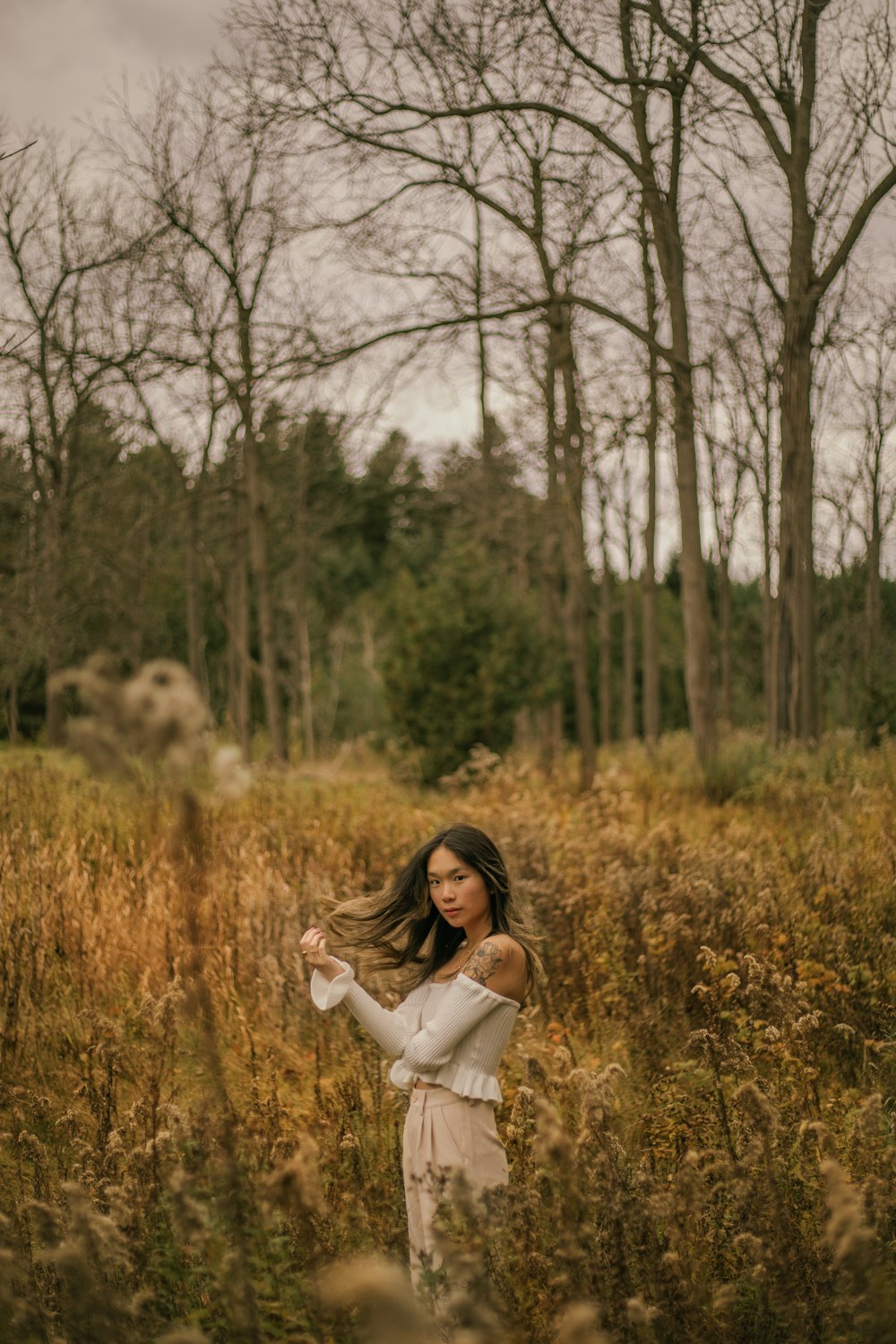 a woman standing in a field of tall grass