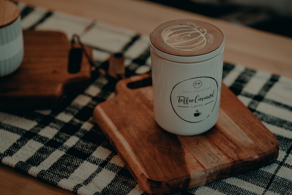 uma xícara de café sentada em cima de uma tábua de corte de madeira