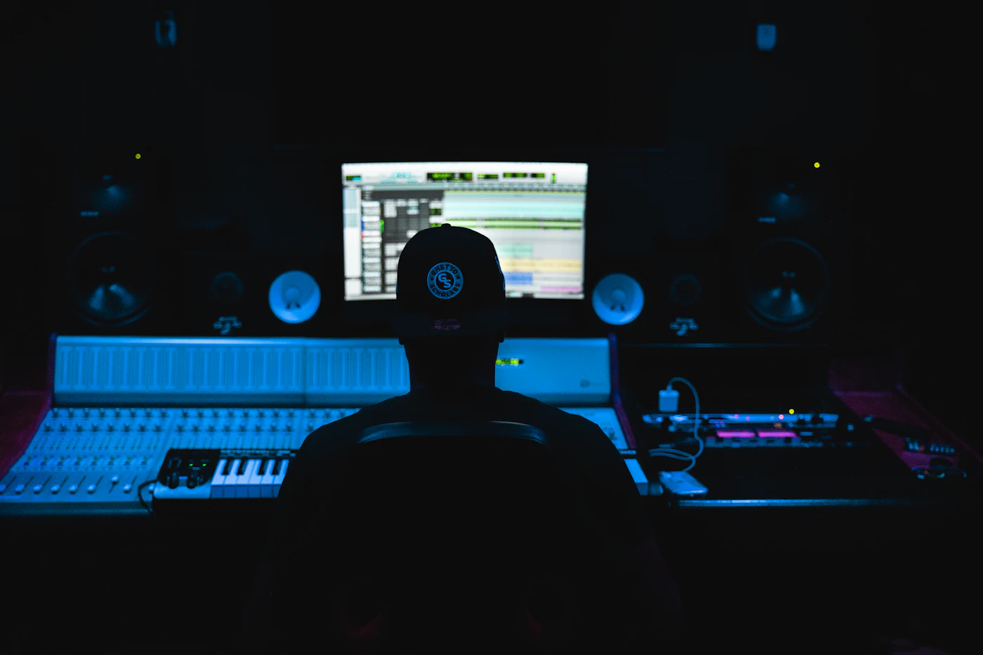 Editor at a mixing console and timeline in a dark studio