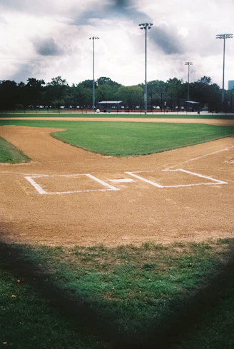 a baseball field with a dirt base and grass