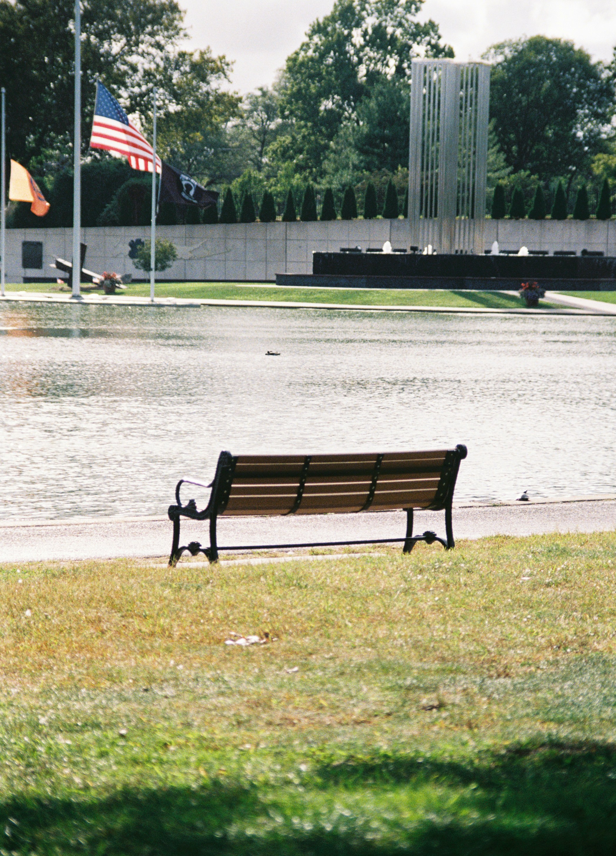 A park bench sitting in front of a body of water photo – Free Kodak ...