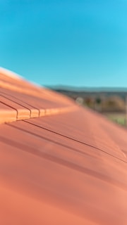 Close-up of a freshly installed terracotta tile roof glistening under the morning sun.