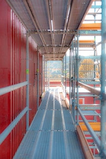 a long hallway with red walls and metal railings