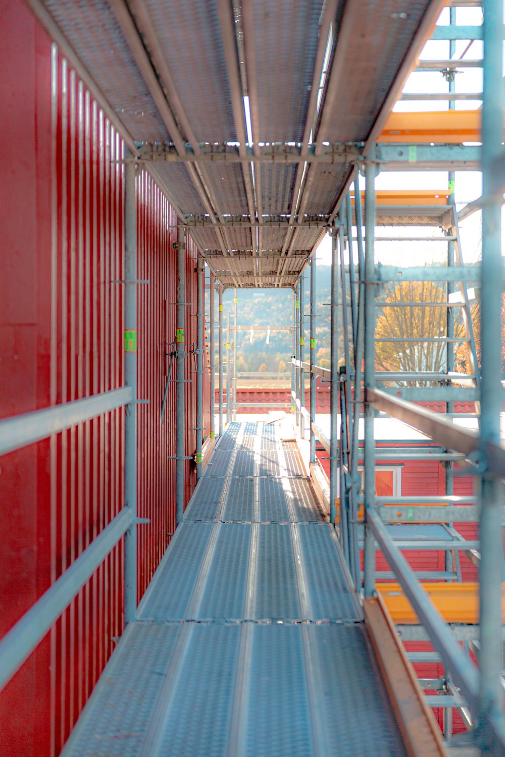 a long hallway with red walls and metal railings