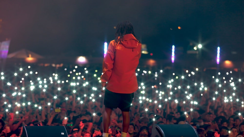 a man standing on top of a stage in front of a crowd