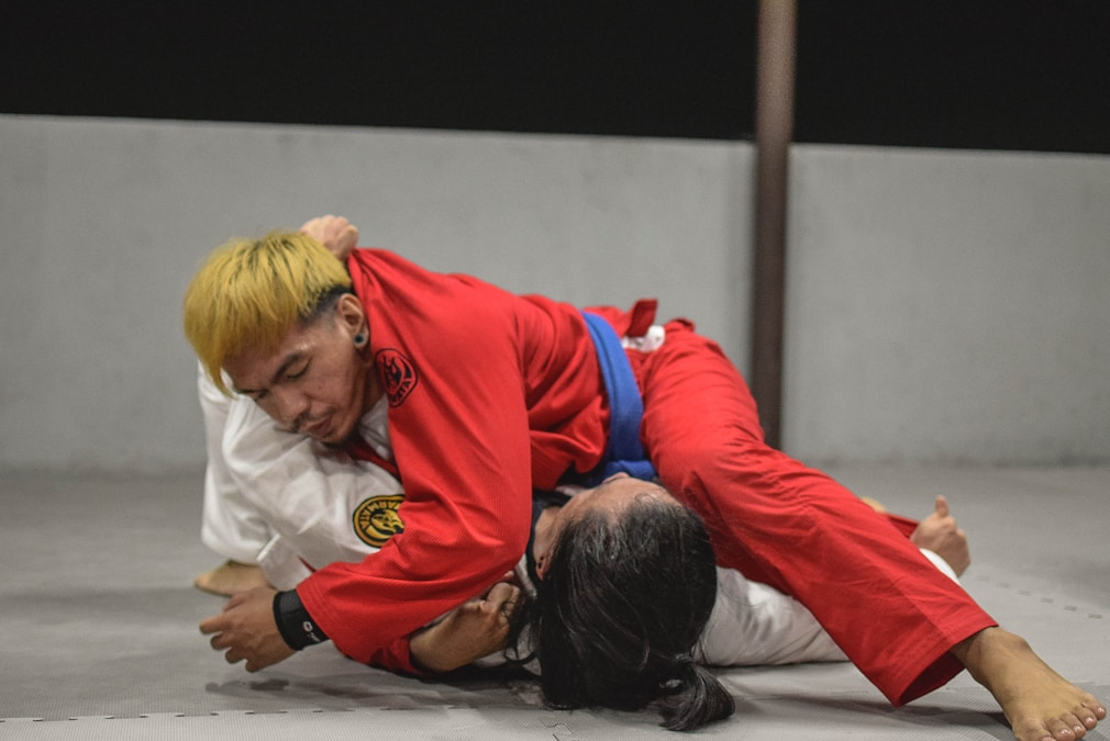 Two grapplers locked in an intense submission grappling exchange on the mat