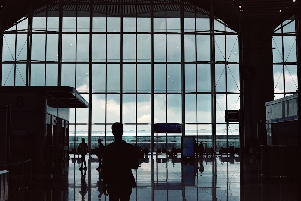 a man standing in front of a window in an airport