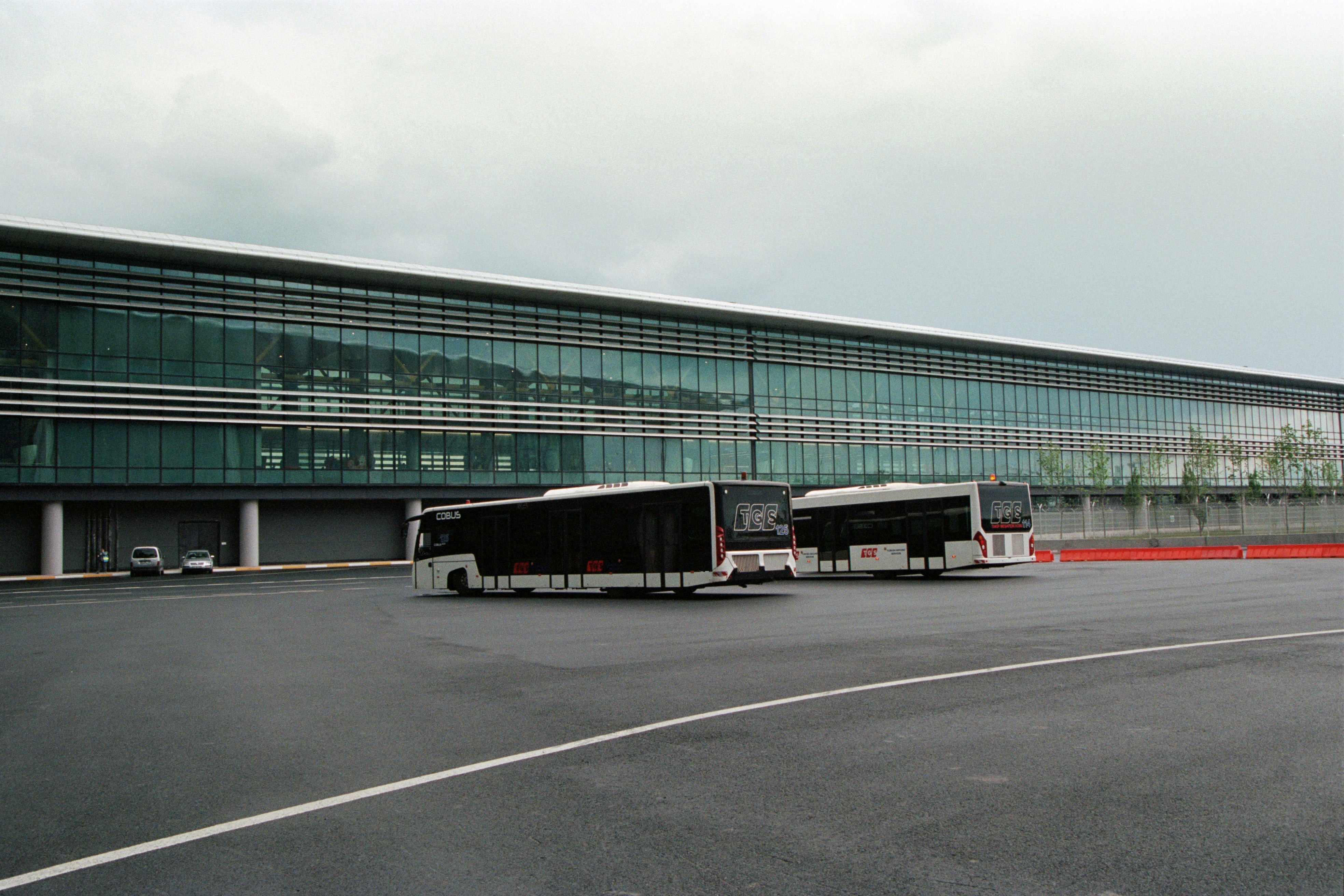 two buses parked in front of a large building