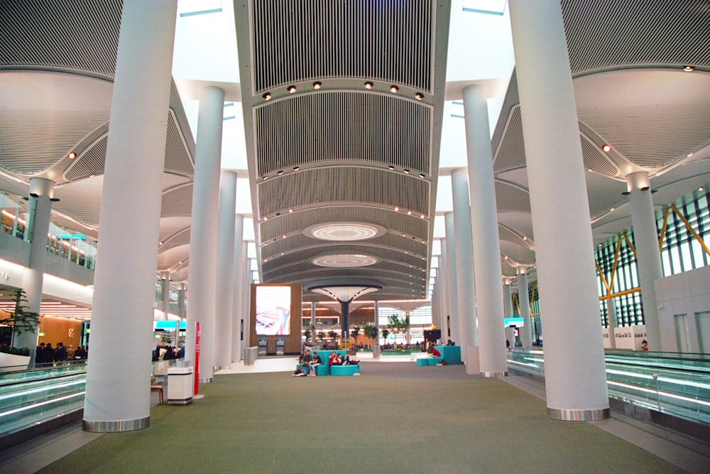 the inside of an airport with people sitting on benches