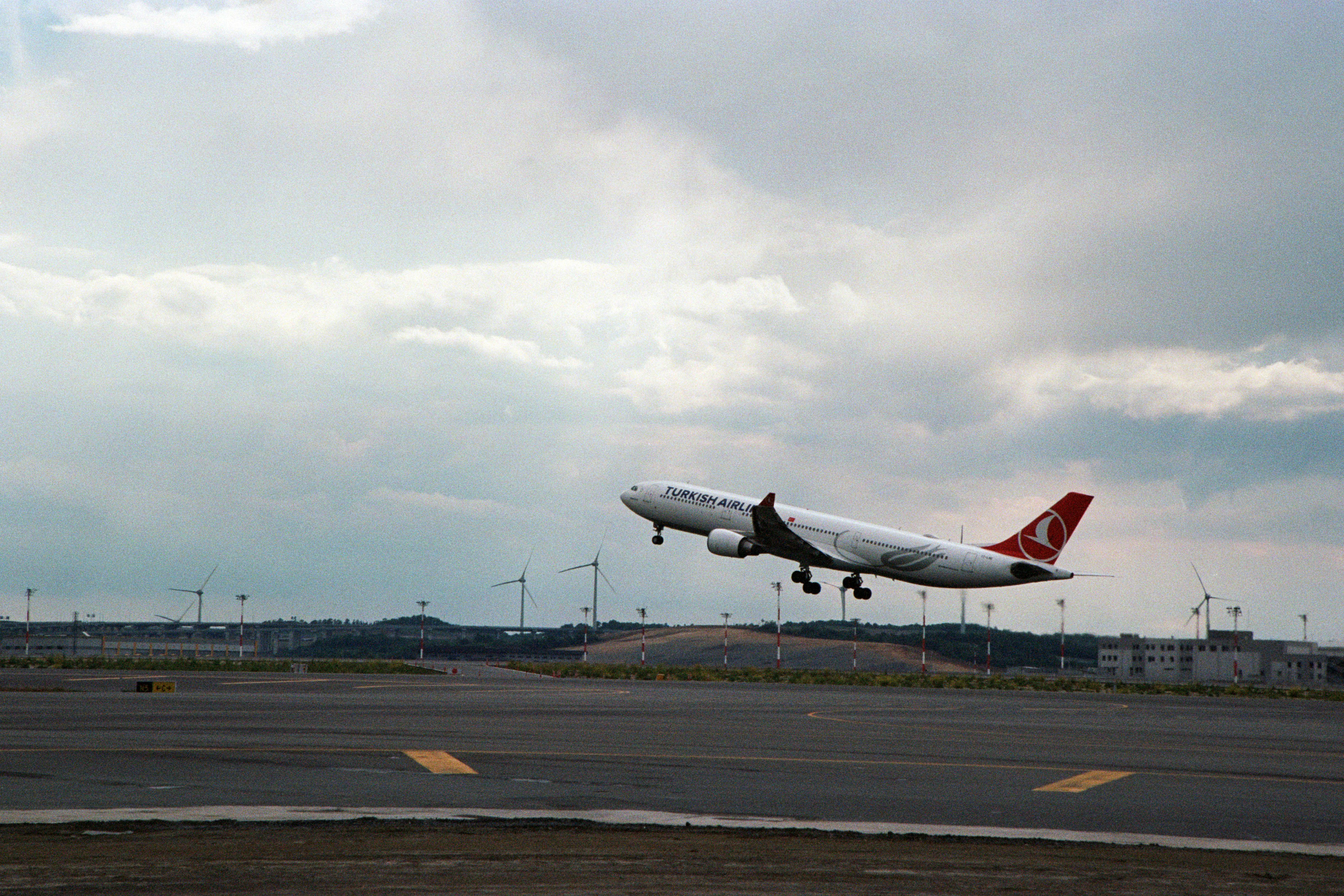 a large jetliner flying through a cloudy sky, 