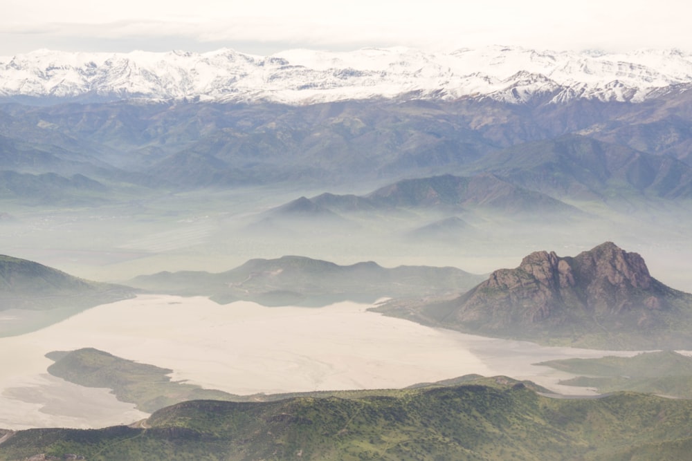 a view of a mountain range with a lake in the foreground