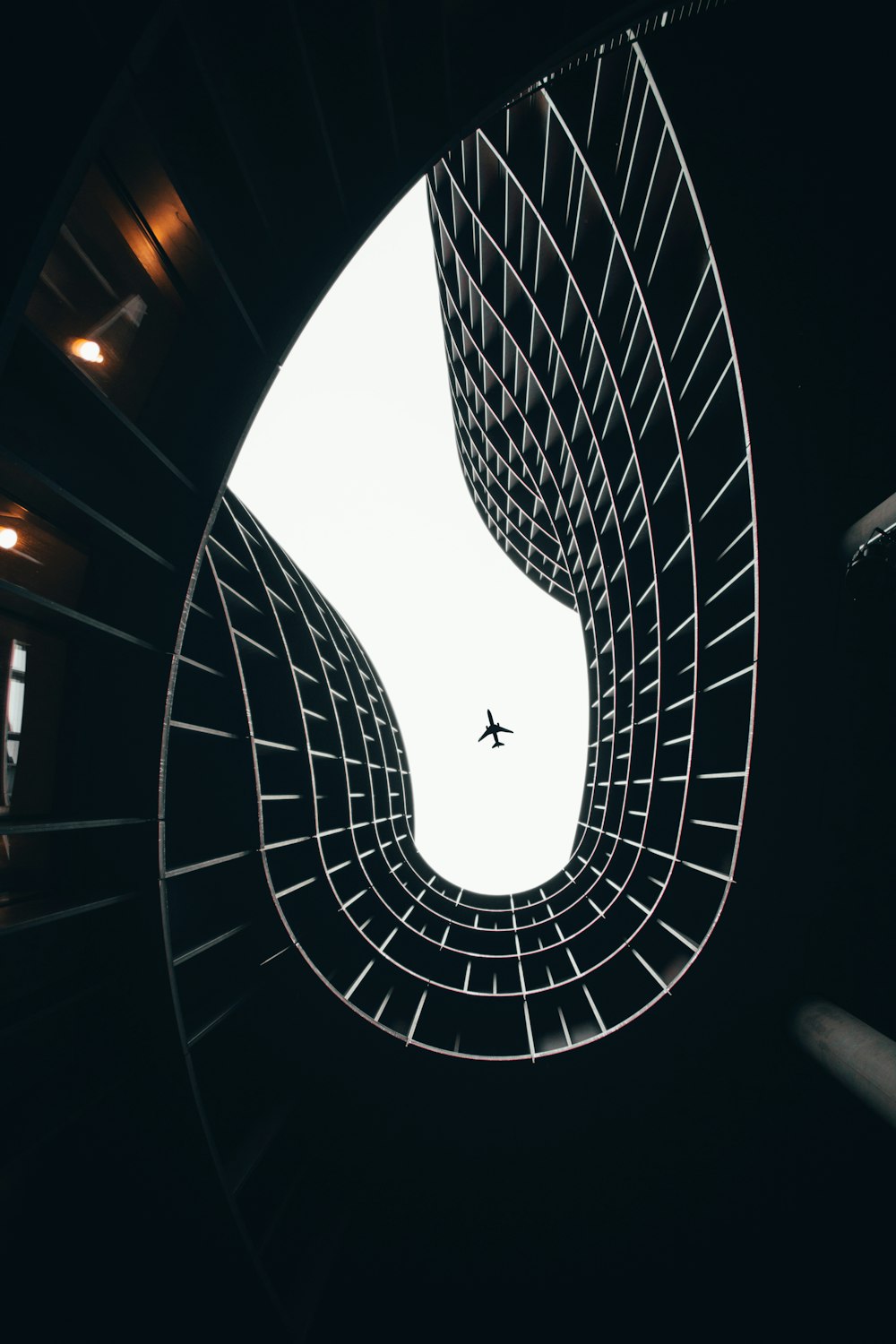 an airplane is flying through a spiral staircase