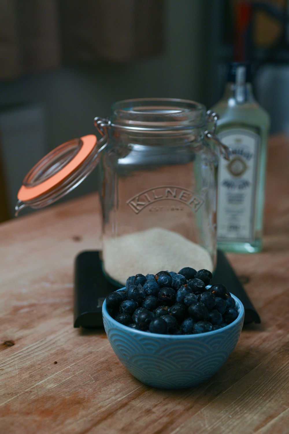 a wooden table topped with a bowl of blueberries