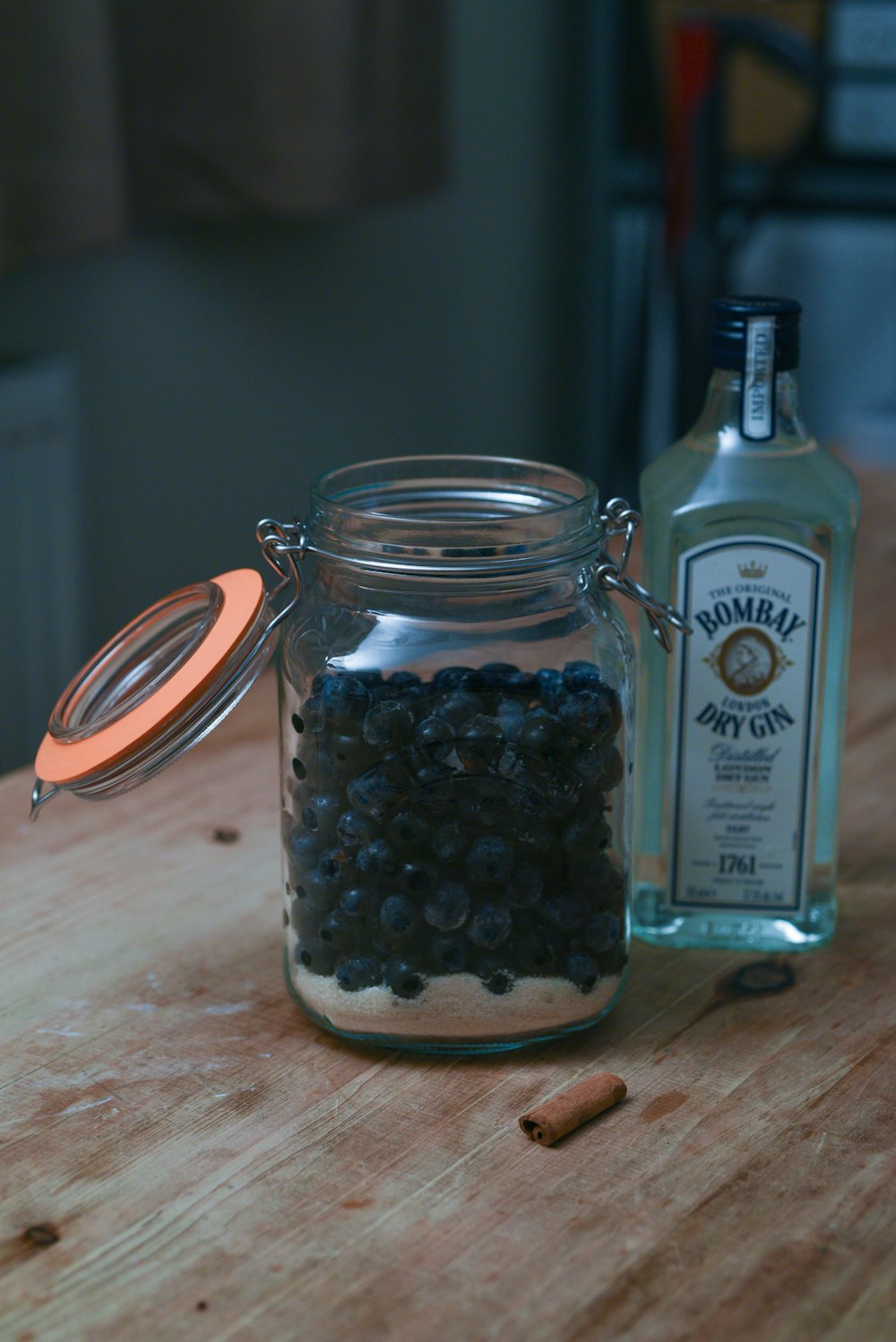 a bottle of alcohol and some black beans on a table