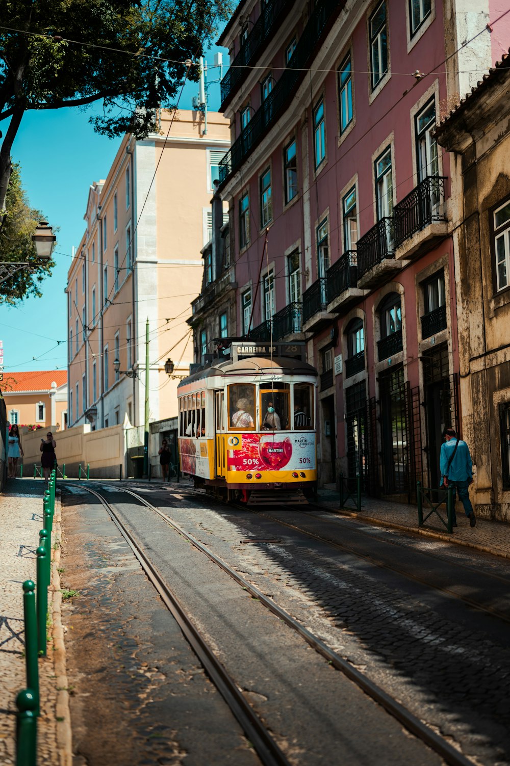 a yellow and white trolley on a city street