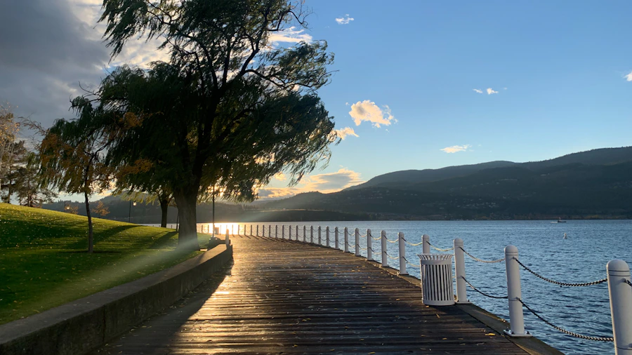 A long wooden dock extending into calm Okanagan Lake on a clear day