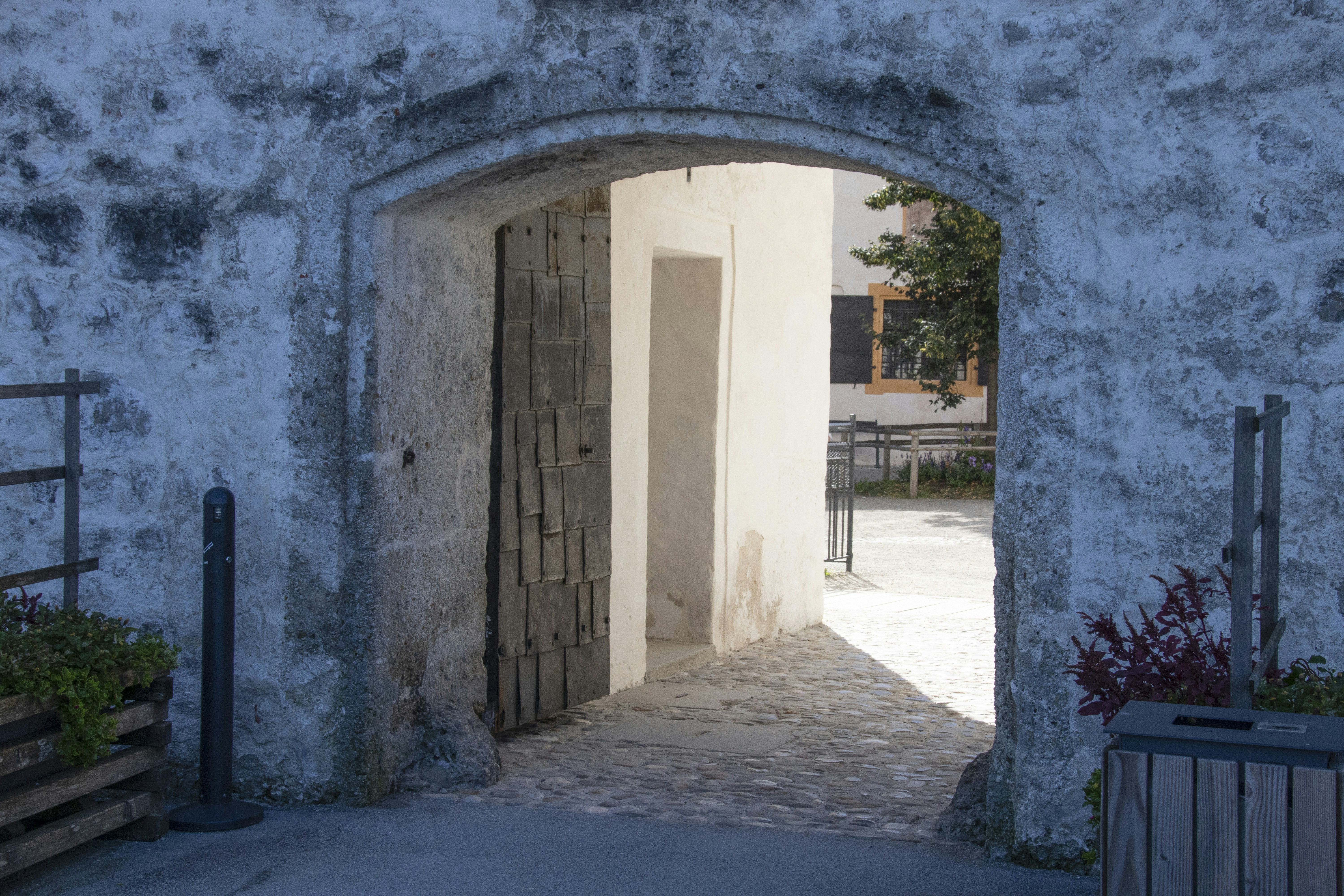 an open door leading into a courtyard with potted plants