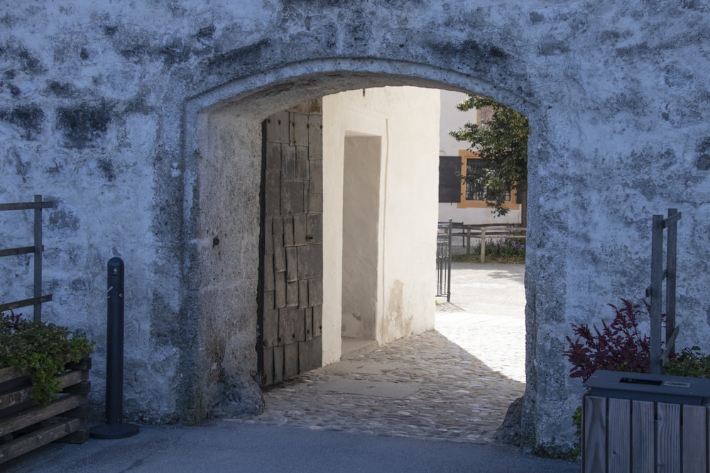 an open door leading into a courtyard with potted plants