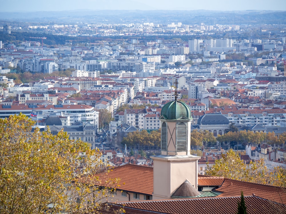 a clock tower on top of a building with a city in the background