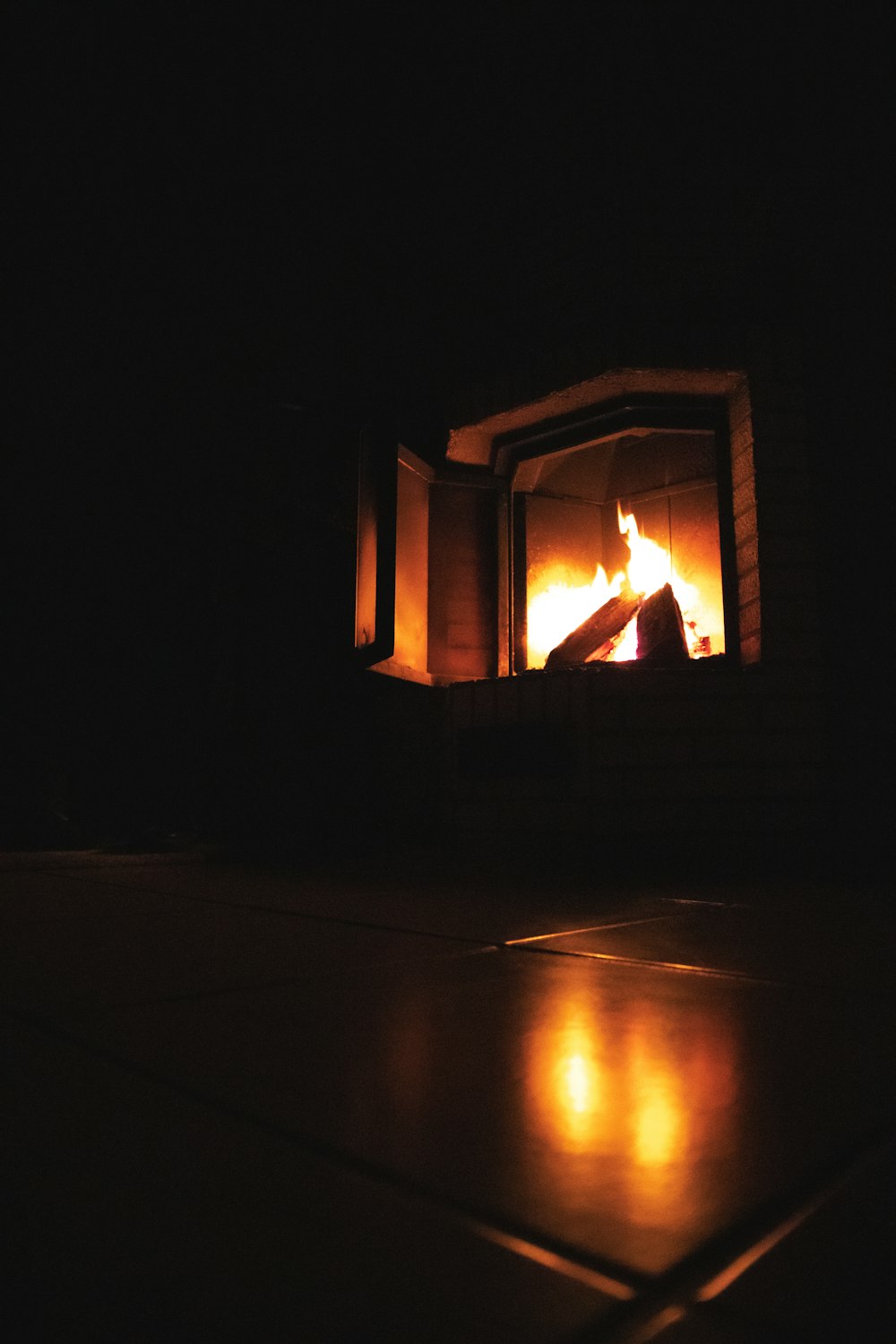 a fire burning in a fireplace in a dark room