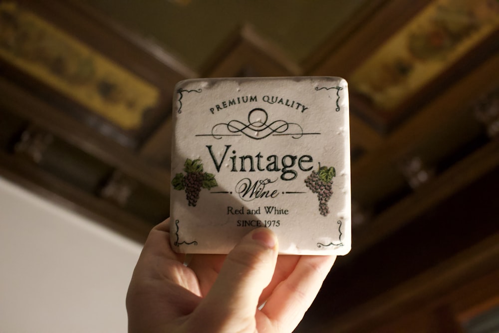 a person holding up a small box of vintage white wine