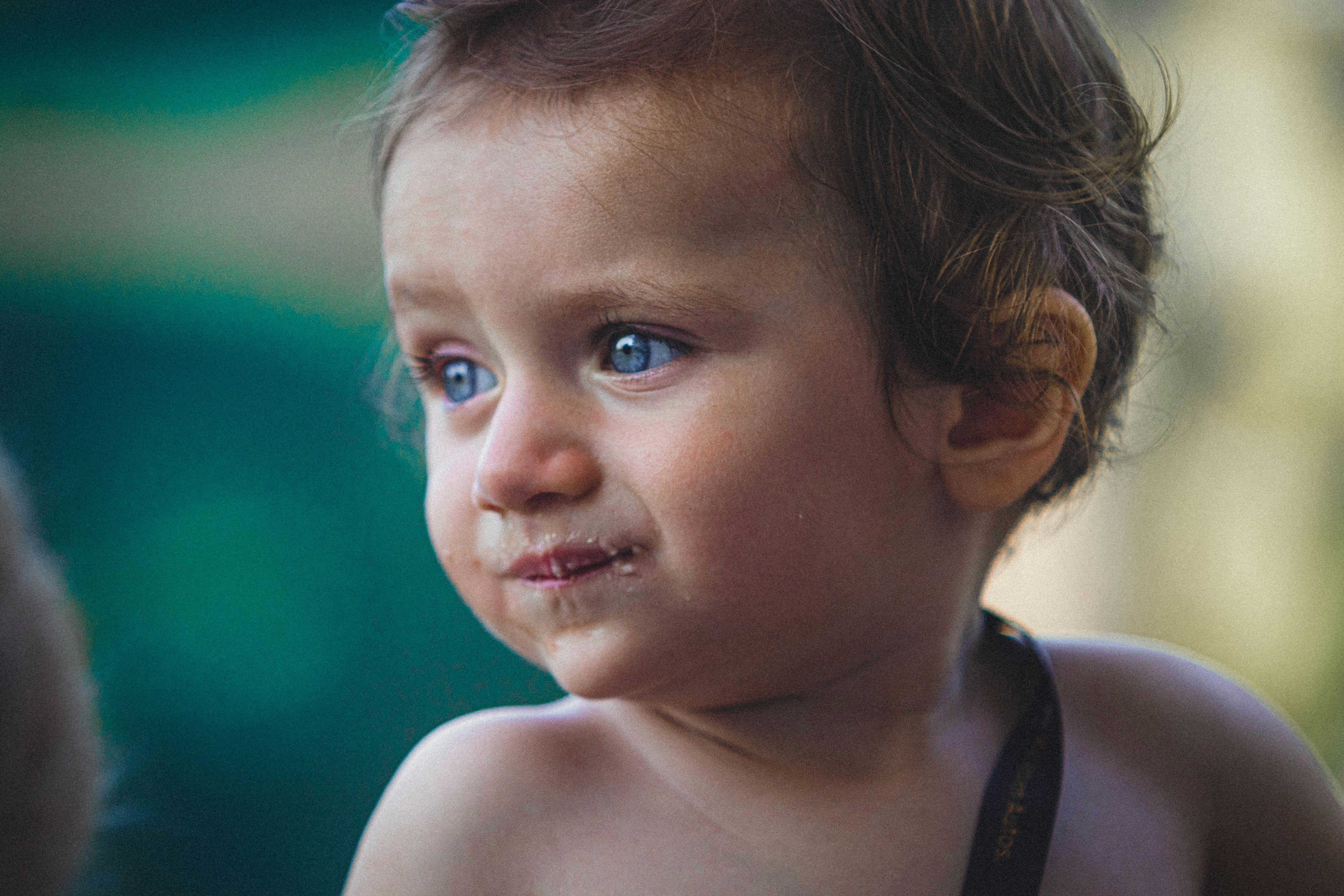 a little girl with a piece of food in her mouth